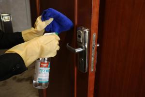 a person in rubber gloves holding a door knob at Rongjiang Hotel in Jieyang