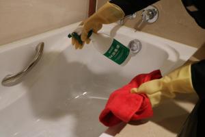 a person is washing a bath tub with a brush at Rongjiang Hotel in Jieyang