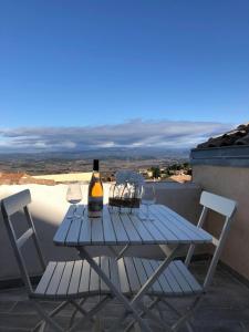 einen blauen Tisch mit 2 Stühlen und eine Flasche Wein in der Unterkunft Provence Luberon Bonnieux location gite chez Marcelle in Bonnieux