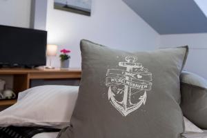 a pillow with a shield and a sword on it at Hotel Keil in Wilhelmshaven
