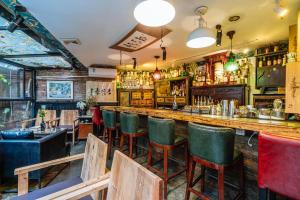 成都POSHPACKER·成都驴友记小院青年旅舍（文殊院店）的餐厅内带绿椅的酒吧