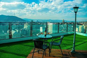 einen Tisch und Stühle auf einem Balkon mit Aussicht in der Unterkunft Hotel Grand View in Tbilisi in Tbilisi City