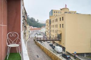 une chaise assise sur le balcon d'un bâtiment dans l'établissement Alegria 79 - Fabulous 3 Bedroom House, à Coimbra