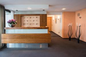 een wachtkamer met een vaas met bloemen aan de muur bij Hotel Kögel in Erbach