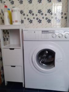 a washer and dryer in a kitchen with a wall at monolocale Sabrina in Torgnon