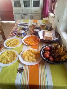 einen Tisch mit Teller mit Lebensmitteln darüber in der Unterkunft NENA HOUSE in Rusatira