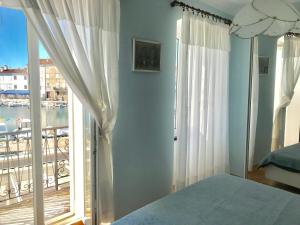 a bedroom with a bed and a window with a balcony at Apartment Duncovich in Cres