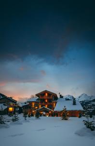 a log cabin in the snow at night at Bed & Breakfast Anisor - Parblanc in La Salle