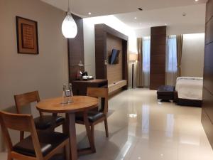 a hotel room with a table and a bed at Hotel Asri Sumedang in Sumedang