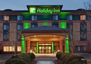 Un edificio de hospital con un letrero verde. en Holiday Inn Manchester Airport by IHG, en Manchester