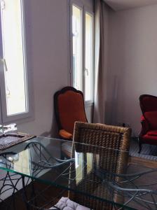- un salon avec une table en verre et deux chaises dans l'établissement Aliénor, à Bordeaux