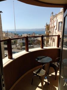balcón con mesa, sillas y vistas en seven7days hotel, en Áqaba