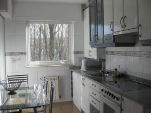 cocina con mesa, fregadero y ventana en Descanso do Sar en Santiago de Compostela