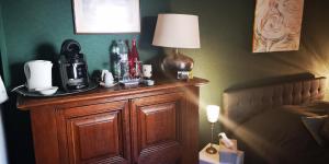 a table with a coffee maker and a lamp on it at La Cour Du Puits Chambre Matcha in Cormeilles