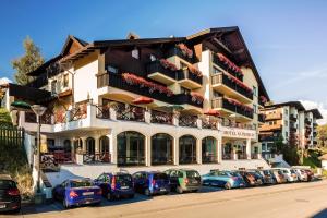 um grande edifício com carros estacionados em frente em Hotel Garni Alpenruh-Micheluzzi em Serfaus
