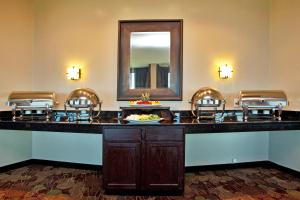 a bar in a hotel room with chairs and a mirror at Holiday Inn New Orleans West Bank Tower, an IHG Hotel in Gretna