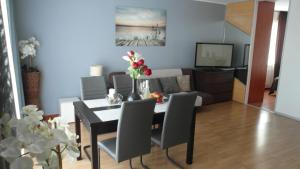 a dining room and living room with a table and chairs at Apartament 50m od plaży z garażem in Władysławowo