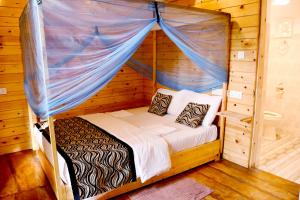 uma cama num quarto de madeira com um dossel em Sasvi Cabana em Trincomalee