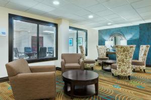 Holiday Inn Express Hotel & Suites Bentonville, an IHG Hotel في بنتونفيل: غرفة انتظار مع كراسي وطاولة