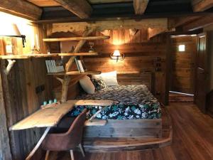 sypialnia w drewnianym domku z łóżkiem i biurkiem w obiekcie Bed & Breakfast Anisor - Parblanc w mieście La Salle