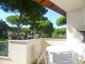 einen weißen Tisch und Stühle auf einem Balkon mit Bäumen in der Unterkunft Residence La Rotonda in Cervia