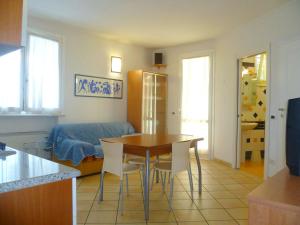 eine Küche und ein Esszimmer mit einem Tisch und Stühlen in der Unterkunft Residence La Rotonda in Cervia