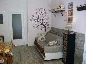 - un salon avec un canapé et un arbre sur le mur dans l'établissement La Poventa, à Tuoro sul Trasimeno