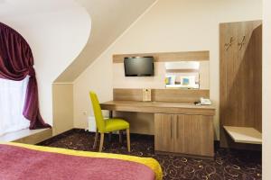 a hotel room with a desk and a tv at City & Business Hotel in Mineralnie Vody