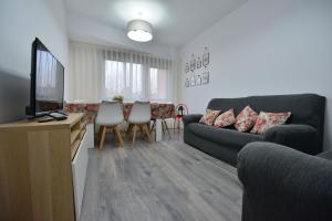 sala de estar con sofá y mesa con sillas en APARTAMENTO ESCALINATA TRIACASTELA, en Santiago de Compostela