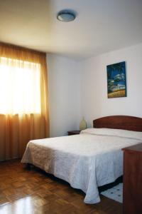 een slaapkamer met een groot bed en een raam bij Apartment Miro in Tar