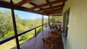 a balcony of a house with chairs and a view at Maitlands Cottage in Port Elizabeth