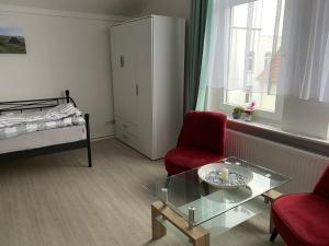a living room with a bed and a glass table at Schöne Ferienwohnung nähe Stadtmitte von Wilhelmshaven in Wilhelmshaven