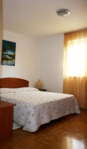 een slaapkamer met een wit bed en een raam bij Apartment Miro in Tar