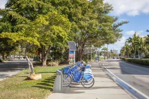 eine Reihe blauer Fahrräder, die auf einem Bürgersteig geparkt sind in der Unterkunft Holiday Inn Miami Beach-Oceanfront, an IHG Hotel in Miami Beach