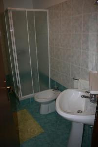een badkamer met een wastafel, een toilet en een douche bij Apartment Miro in Tar