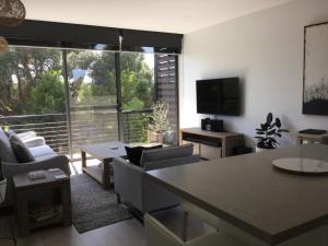 a living room with a large window and a television at The Moonah Apartment 29 in Fingal