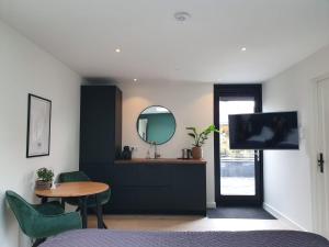 a bedroom with a table and a mirror and a television at Studio Smidt in Den Burg