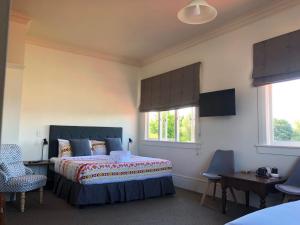 a bedroom with a bed and two windows at Penmarric House - Self Check-in in Cambridge