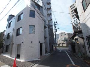 an empty street with a white brick building at Belle harmonie togoshi101 in Tokyo