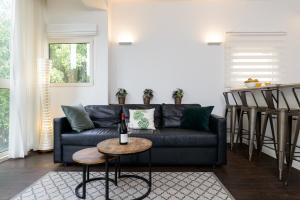 a living room with a black couch and a table at Arlozorov by TLV2RENT in Tel Aviv