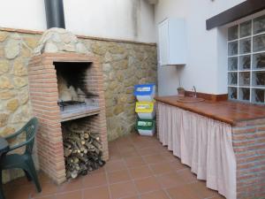 a kitchen with a brick fireplace with a stove at Casa Rural Las Nogueras in Caserío Arroyofrío