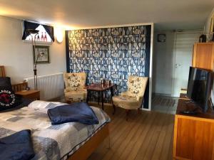 a bedroom with a bed and a table and chairs at Rum i villa - Kärleksudden Norrtälje in Norrtälje