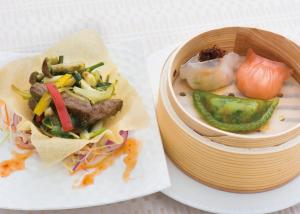 a plate with a bowl of food and a bowl of vegetables at Konaya Hotel in Kofu