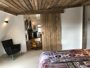 een slaapkamer met een bed en een stoel in een kamer bij Spinnerei in Spechtholzhock