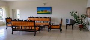 a room with several wooden chairs and a tv at Camellia Heights 1&2 in Coonoor