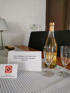 Una botella de vino y dos copas en una mesa. en Ferienhaus Albers, en Oberlangen