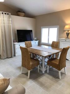 a dining room with a table and chairs and a television at Provence Luberon Bonnieux Location Gite Chez Basile in Bonnieux