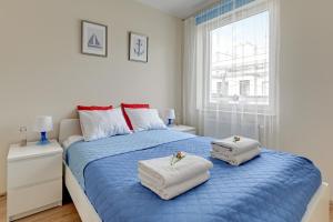 a bedroom with a blue bed with two towels on it at TriApart Amber Jantar in Jantar