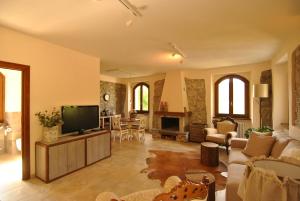a living room with a flat screen tv and a living room at B&B Casale delle farfalle in Tornolo