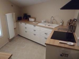 a kitchen with white cabinets and a sink and a refrigerator at Provence Luberon Bonnieux Location Gite Chez Basile in Bonnieux